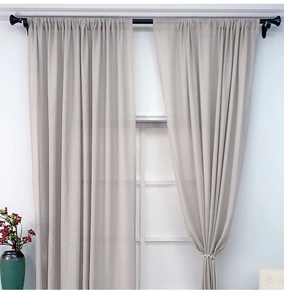 Detailstruktur beiger Leinenmischvorhänge mit elegantem Perlen-Raffhalter im modernen Raum
