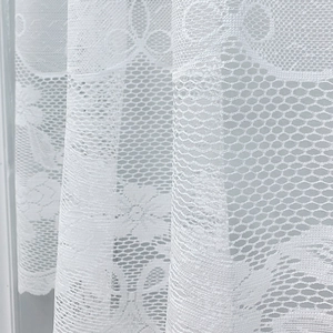 White lace cafe curtain with delicate floral patterns and honeycomb mesh texture