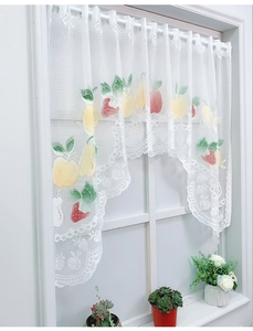 Detailed lace cafe curtain with fruit prints and decorative scalloped edges on a window