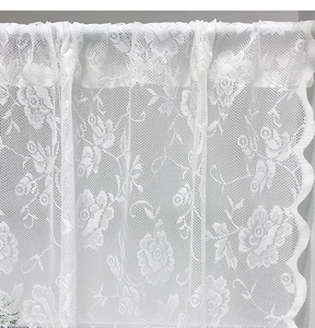 Detail of white lace door curtain featuring 3D floral embroidery and scalloped edges