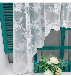 Detailed view of floral lace pattern and elegant scalloped edge on white kitchen curtain