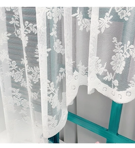 Macro view of white floral lace curtain with embroidered roses and scalloped edge detail