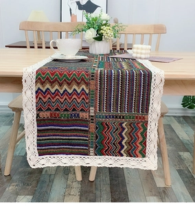 Detailed view of bohemian jacquard table runner with vintage lace edges on a wooden table