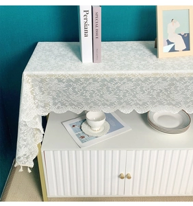 Close-up of white lace table runner with floral embroidery and wavy scalloped edges
