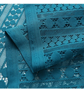 Makro-Detail von pfauenblauem Häkel-Spitzenstoff mit geometrischen Mustern für Vorhänge