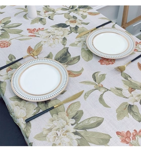 Detailed close-up of pastoral floral print on rectangular linen tablecloth with natural texture