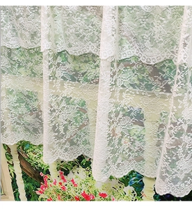 Detailed close-up of premium white lace fabric with elegant embroidery and wavy edge
