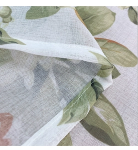 Macro detail of pastoral floral print on linen texture tablecloth with neat edge stitching