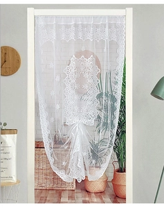 Gros plan détaillé d'un rideau en dentelle blanche avec broderie florale et bord festonné