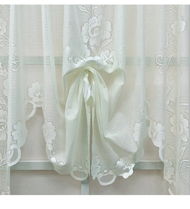 Detail of white lace Roman curtain featuring floral embroidery and bow tie design