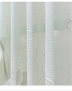 Detailed view of white floral lace curtain fabric with elegant mesh embroidery texture