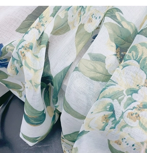 Macro shot of semi-transparent fabric with green leaf and yellow flower floral patterns