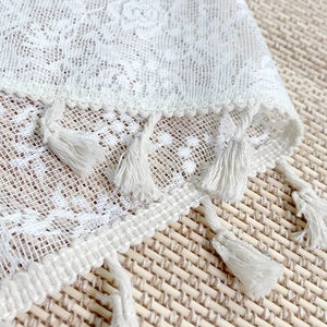 Modern white lace table runner with elegant rose floral patterns and woven fringe trim