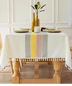 Close-up of cotton linen tablecloth with colored stripes and delicate white tassels