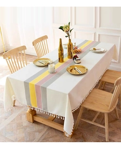 Detail of elegant striped cotton linen tablecloth with white decorative fringe edges