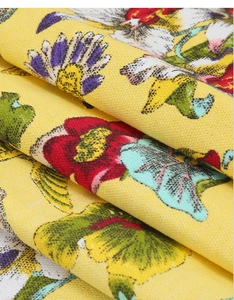 Macro shot of tropical flower patterns on cross-weave textured yellow table runner fabric