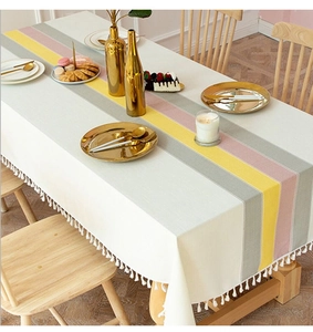 Detailed macro view of minimalist striped linen tablecloth with decorative cotton tassels