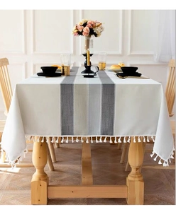 Close-up of striped cotton linen tablecloth featuring tassel edge and elegant texture