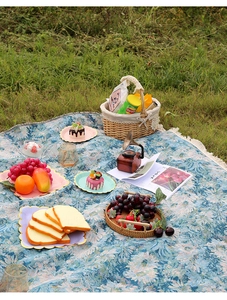 Détail du tapis de pique-nique à fleurs bleues avec tissage épais et franges sur l'herbe
