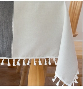 Detailed view of striped cotton linen tablecloth with elegant white fringe tassel edge
