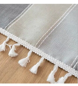 Close-up of striped cotton linen tablecloth featuring elegant white tassel fringe details