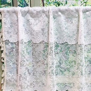 White rose lace kitchen curtain with beige tassels in a vintage farmhouse style