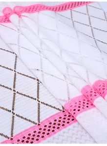 Detail of Nordic table runner with white lace cutout and pink floral embroidery edge