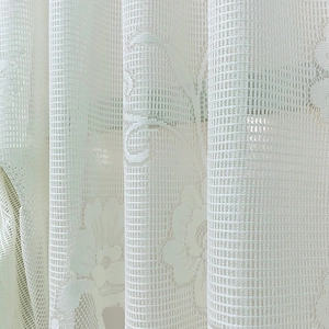 White floral lace roman shade curtain featuring sheer mesh fabric and textured patterns