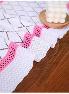 Close-up of Nordic lace table runner with black diamond mesh and pink hollowed edges