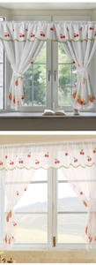 Close-up of white cafe curtain with fresh pineapple embroidery and green wavy edge