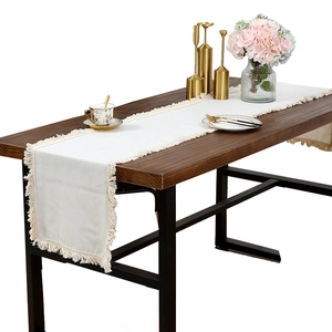 Chemin de table minimaliste en lin avec glands sur table en bois avec décor élégant
