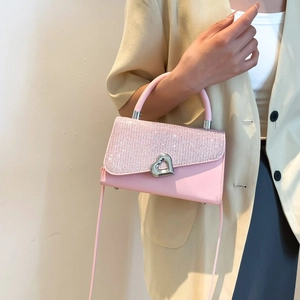 Pink crossbody bag with sparkly rhinestones and heart buckle on a yellow blazer outfit