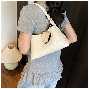 Detailed macro of the woven beige faux leather hobo bag with a matching small coin purse