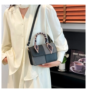 Detail of grey plaid crossbody bag with silk scarf handle and gold metal lock
