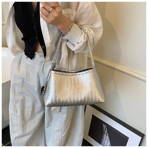 Macro shot of silver woven texture on a minimalist shoulder bag for women
