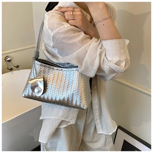 Detail of silver woven hobo bag showing metallic texture and knotted handle on shoulder