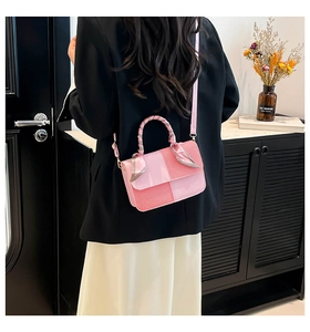 Detailed view of pink checkered crossbody bag with scarf-wrapped handle and slim strap