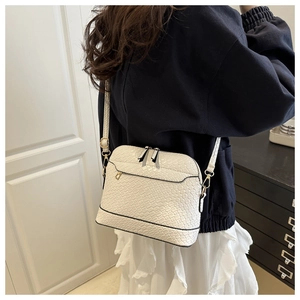 Detailed view of white woven texture PU leather shell bag on a model shoulder