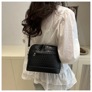Detail of woven texture and golden hardware on black large crossbody shell bag