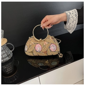 Detailed embroidery and sequins on the evening clutch bag with a gold ring handle