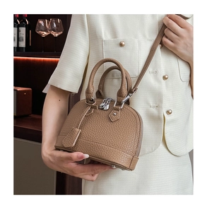 Detail der karamellfarbenen Muscheltasche mit Lychee-Struktur und verstellbarem Schultergurt