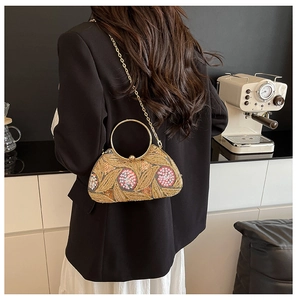 Detail of floral sequin embroidery and gold metal ring handle on vintage evening bag