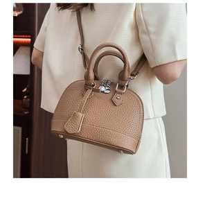 Nahaufnahme der braunen Muscheltasche mit Litschi-Muster und silbernen Metallteilen
