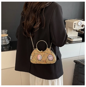Detail of sequined evening bag featuring vintage floral embroidery and round metal handle