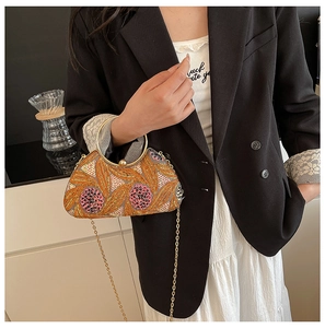 Close-up of sparkling sequin beaded floral pattern and luxury gold metal round handle