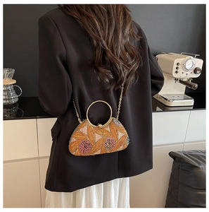 Detail of sequined evening clutch with floral embroidery and gold metal ring handle