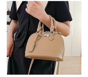 Nahaufnahme der khakifarbenen Muschel-Tasche mit Litschiprägung und Silber-Zippern