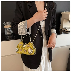 Detail of yellow sequin evening bag with gold floral embroidery and round metal handle