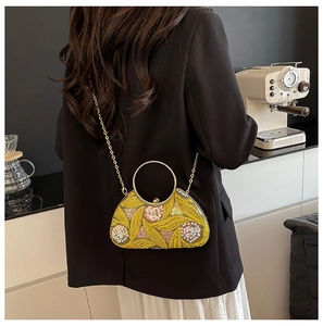 Detail of yellow sequined evening bag with golden round handle and chain strap