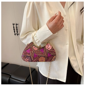 Detailed close-up of heavy floral embroidery and purple sequins on a box evening clutch